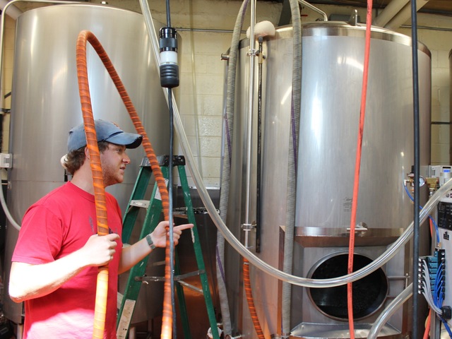 Brewer's assistant Simon Cox, 24, in red at left, prepares to pull yeast from one of Sixpoint Brewery's 465-gallon tanks.