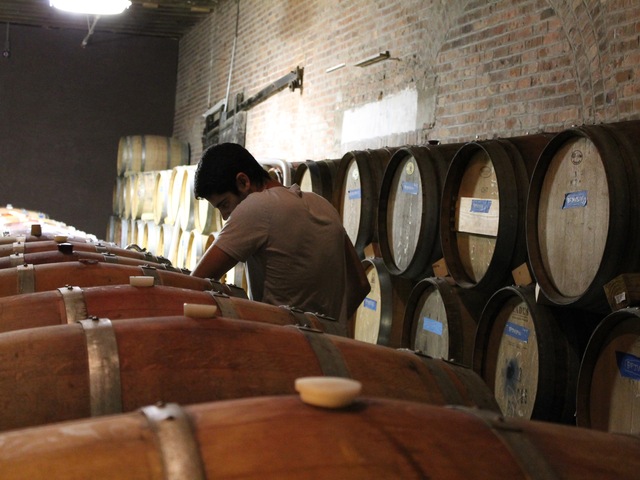 Red Hook Winery cellar master Ben Nicholas tops-off casks of wine.