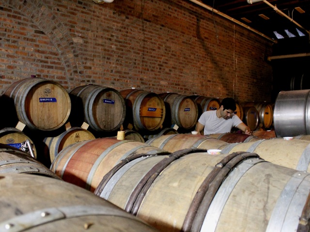 Red Hook Winery cellar master Ben Nicholas tops-off casks of wine.
