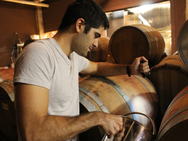 Red Hook Winery cellar master Ben Nicholas tops-off casks of wine.