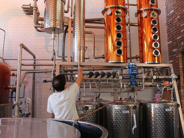 Distiller Layton Cutler, 33, checks the hydrometer on Cacao Prieto's still, which measures the amount of water in the alcohol moving through the still.