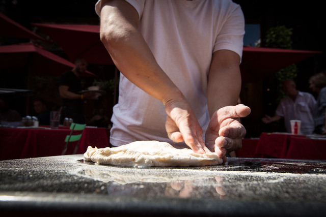 Hernandez prepares the flour for the pizza before tossing it on Mulberry Street September 1, 2012.