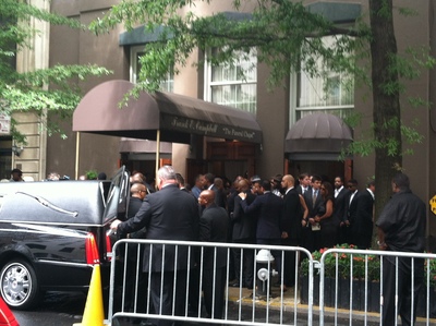 Chris Lighty's casket was brought out to the hearse as a crowd on the sidewalk looks on.