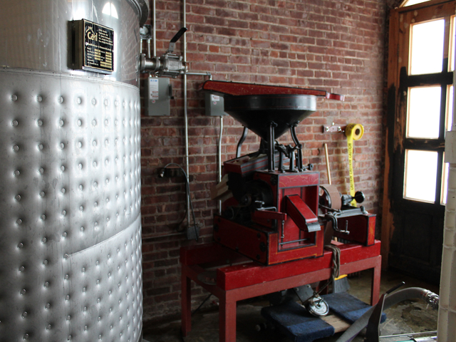 Cacao Prieto produces its liquors and chocolates at its 7,000-square-foot factory, which includes a large silver mash tank (left) and a grain mill (right).