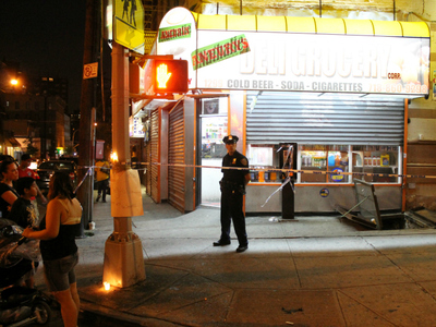 A police officer stands guard outside the bodega where Reynaldo Cuevas was killed.