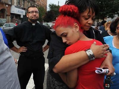 Carmen Berganzo is comforted by Rev. Que English during a vigil for Reynaldo Cuevas, as Rev. Ruben Austria looks on. 