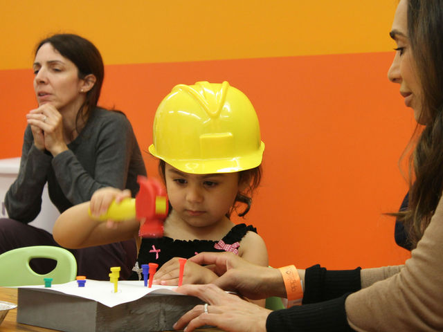 <p>Hammering nails during construction class.</p>
