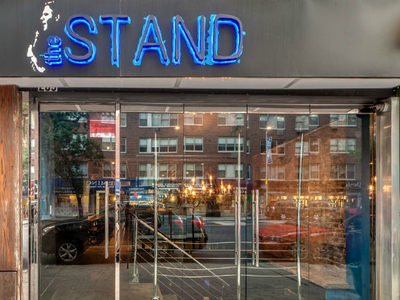 The owners of The Stand worked closely with Mike DeStefano, a comedian who died in 2011, and chose to pay tribute to him by including a black-and-white rendering of the late comic as part of their logo and signage. 