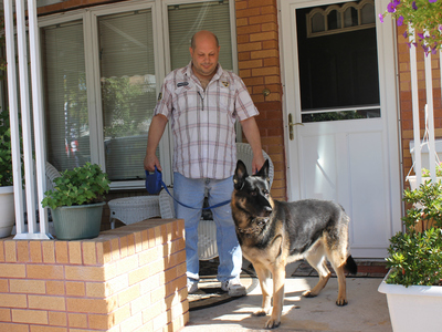 Joseph Butrico and his dog Maxwell inside their Marine Park Home. The city fined Butrico after neighbors complained about Max's excessive barking.