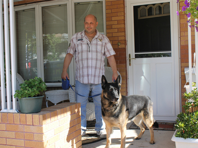 Joseph Butrico and his dog Maxwell inside their Marine Park Home. The city fined Butrico after neighbors complained about Max's excessive barking.