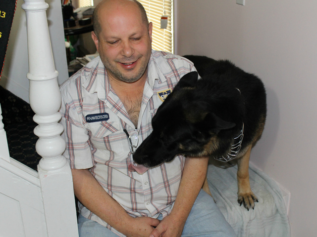 Joseph Butrico and his dog Maxwell inside their Marine Park Home. The city fined Butrico after neighbors complained about Max's excessive barking.