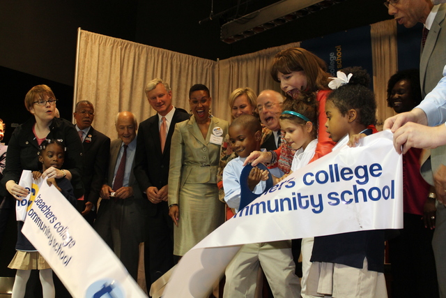Students at Teachers College Community School cut a ceremonial ribbon with officials.