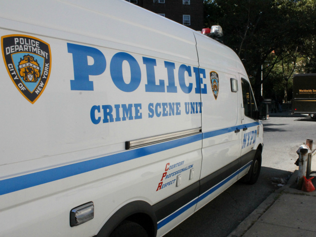 A Crime Scene Unit van outside of the public housing building.