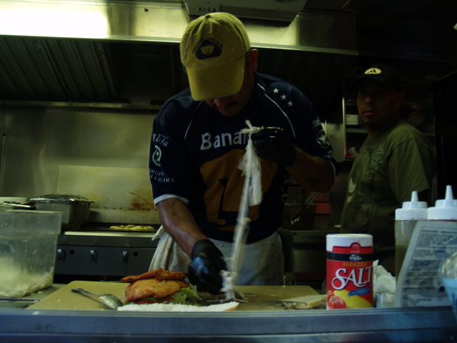 Galdino Molinero puts together the Tortas Pumas, a $14 sandwich that includes chicken cutlets, eggs, ham, beans, cheese and fried hot dogs, at the Viva La Comida! festival.