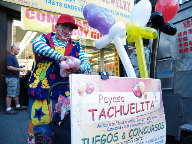 A local clown makes balloon animals at the Viva La Comida! festival in Jackson Heights.