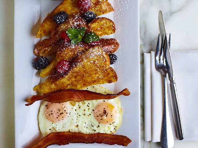 <p>Crema serves French toast with citrus flavored maple pecan syrup, citrus, fried egg and bacon.</p>
