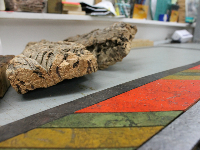 Bark from a cork oak tree beside some colored cork tiles made by Globus Cork.