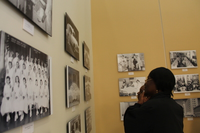 Visitors look at historical photographs of Harlem Hospital inside the wing's gallery.