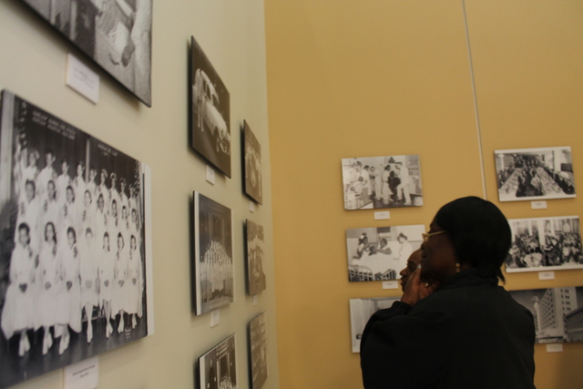 Visitors look at historical photographs of Harlem Hospital inside the wing's gallery.