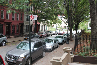 <p>Cars turn onto Hamilton Terrace, a quaint side street, and speed up the block.</p>
