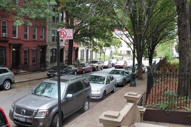 Cars turn onto Hamilton Terrace, a quaint side street, and speed up the block.