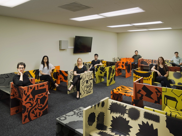 <p>Carin Goldberg (lef) with SVA students posing in chairs they re-purposed as part of a project for a probation center renovation in New York.</p>
