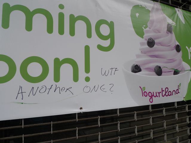 <p>Graffiti on Yogurtland's "Coming Soon" banner seems to complain about the influx of frozen yogurt shops in Park Slope.</p>
