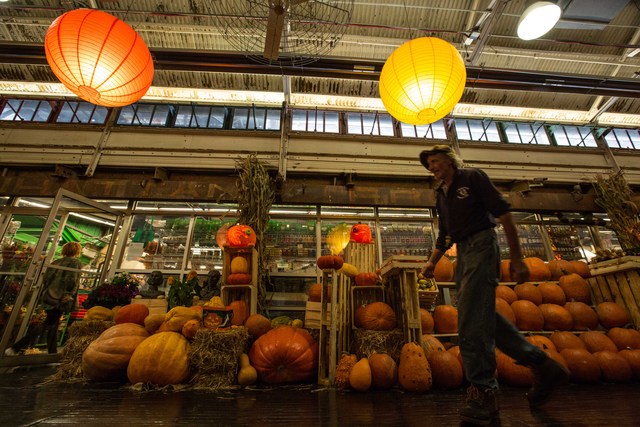 A passer-by walk by Hugh McMahon's exhibitions at Chelsea Market