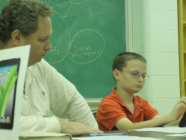 <p>Tom Sr. and Tommy Cusack work on a story during the Autism Initiatives iPad storytelling class at the Forest Park Library on Oct. 1, 2012.</p>
