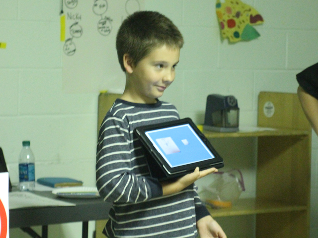 <p>A child shows off a finished story during the Autism Initiatives iPad storytelling class at the Forest Park Library on Oct. 1, 2012.</p>
