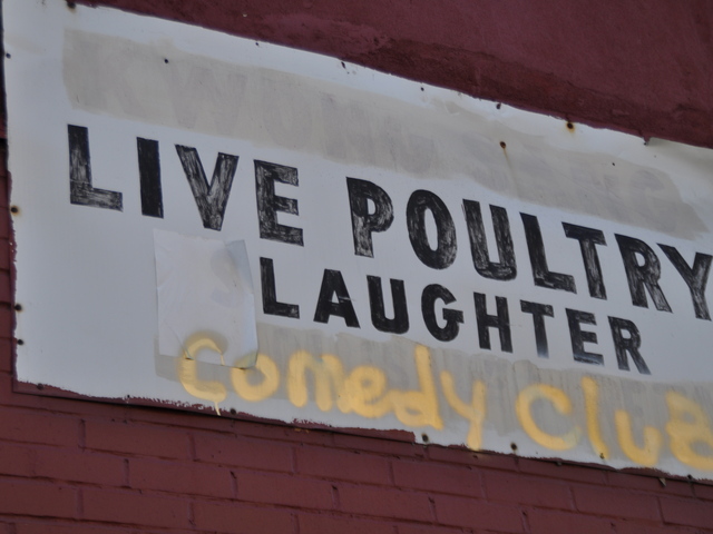 <p>The sign for Lee's Live Poultry Slaughter has been graffitied to read "Live Poultry Laughter Comedy Club."</p>
