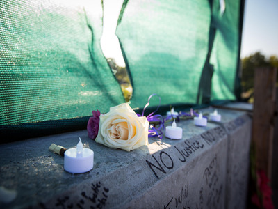 <p>Mourners write slogans such as "No justice, no peace" on Noel Palanco's memorial.&nbsp;</p>
