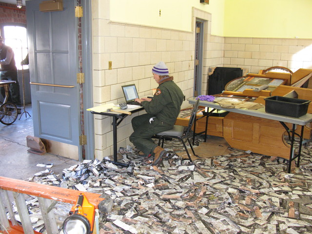 <p>A Parks worker documents Hurricane Sandy damage amid a carpet of brochures strewn about by floods.&nbsp;</p>
