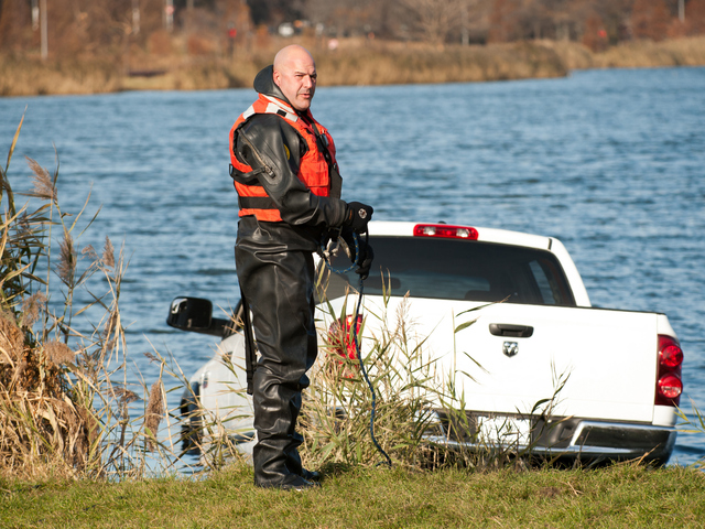 <p>An Emergency Service Unit officer prepares to attach chains to the pickup Monday morning, Nov. 19, 2012.</p>
