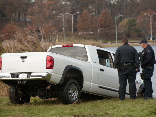<p>Officers stand next to the pickup truck as it's removed from Meadow Lake in Forest Hills Monday morning, Nov. 19, 2012.</p>
