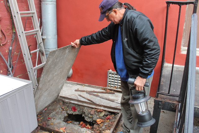 <p>Army veteran Eddie Acosta, 66, looks at a hole in the concrete patio behind VFW Post 5195 in Red Hook. The hole opened as floodwaters from Hurricane Sandy built up around the post, sending water cascading into the post's basement.</p>
