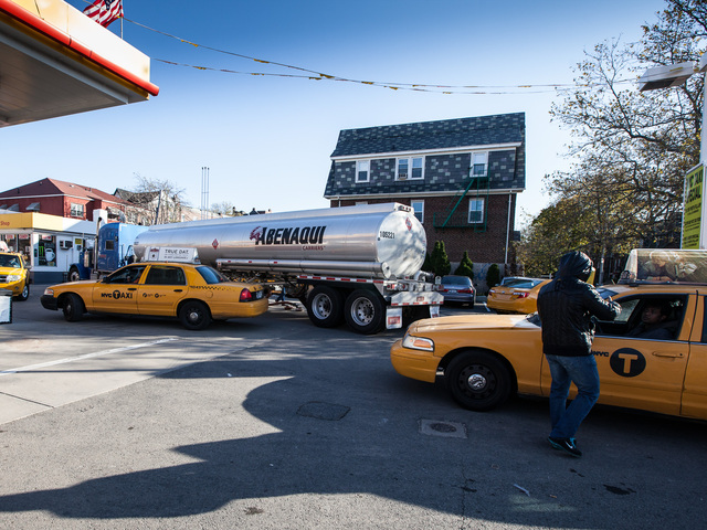 <p>An attendant at the Shell gas station on Northern Blvd., Queens directs yellow cabs to the fuel pumps on Nov. 9, 2012.</p>
