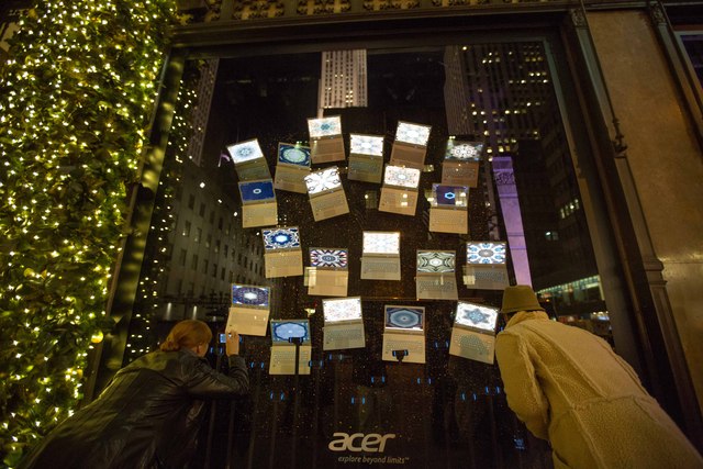 <p>Onlookers tried to take picture of a Saks' windows on Fifth Avenue</p>
