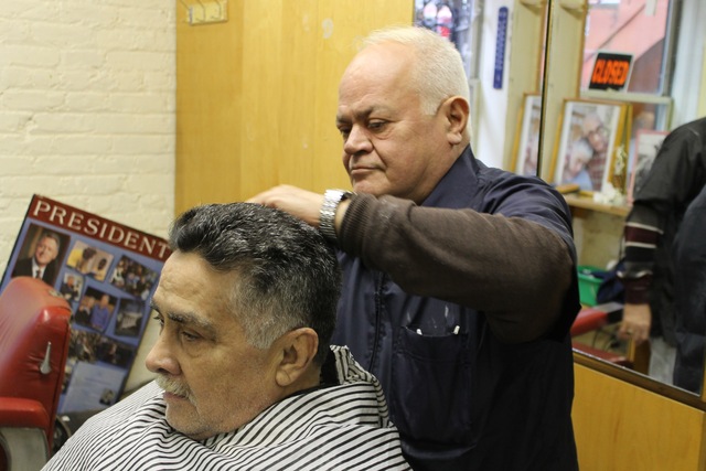 <p>William Narcado gives a client a haircut at his new barber shop on West 18th Street.</p>
