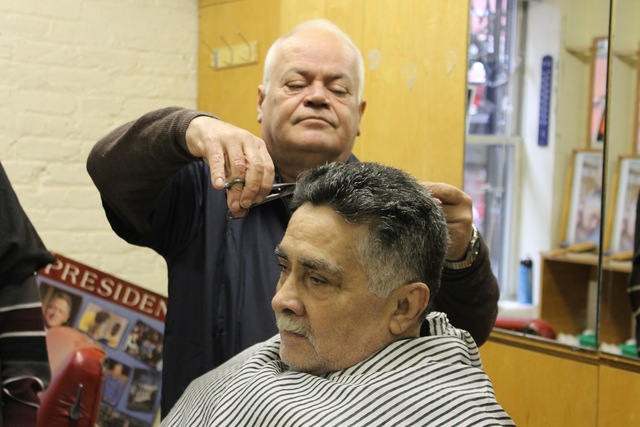 <p>William Narcado gives a client a haircut at his new barbershop on West 18th Street.</p>
