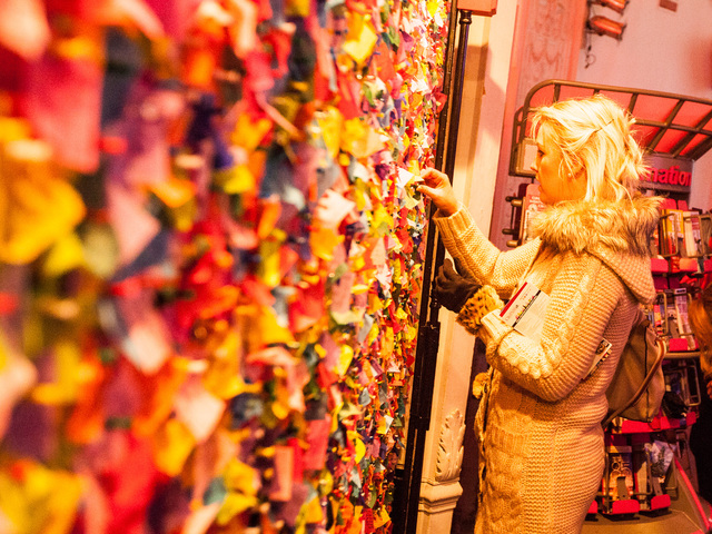 <p>Caoimhe McGiven, 28, from Northern Ireland, pins her confetti wish on the New Year's Eve Wishing Wall at the Times Square Museum on Dec. 29th, 2012.</p>
