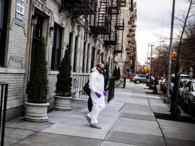 Investigator in a hazmat suit leaves an apartment where a man was found dead December 22, 2012, after a smell emerged over a week's time, neighbors said.