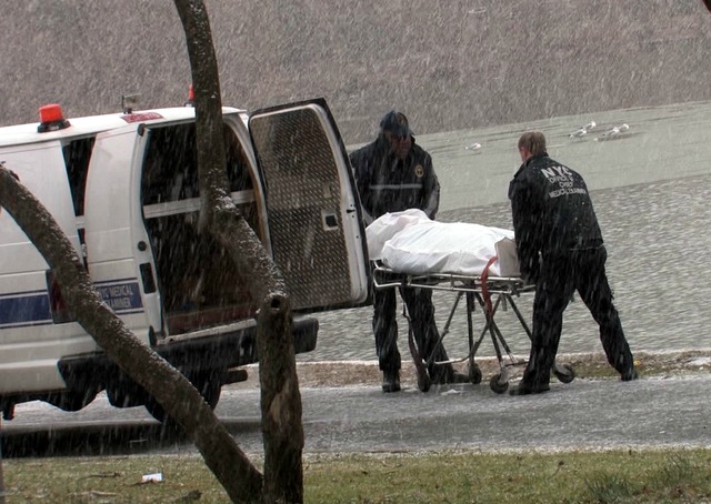 <p>A woman's body is loaded into a van outside Kissena Lake on Dec. 29, 2012.</p>
