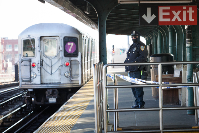 <p>A police officer stands watch as a 7 train approaches 40th Street Station in Sunnyside Friday morning, Dec. 28, 2012.</p>
