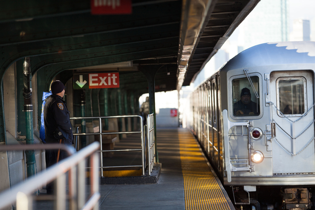<p>Police officers stand watch as a 7 train approaches 40th Street Station in Sunnyside Friday morning, Dec. 28, 2012.</p>
