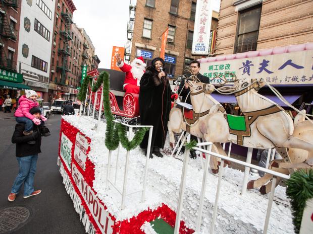 <p>Santa Claus waves to crowds alongside singers Cheryl Warfield and John Carelli at the annual East Meets West Parade in Chinatown & Little Italy on Dec. 22nd, 2012.</p>