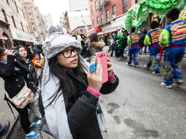<p>A young girl takes pictures of the New York United Lion and Dragon Dance Troupe at the annual East Meets West Parade in Chinatown & Little Italy on Dec. 22nd, 2012.</p>
