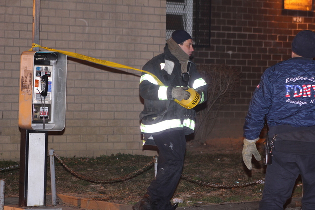 <p>A rescue worker cordons off an area around a fatal fire in Brooklyn, which left a woman dead on January 26, 2013</p>
