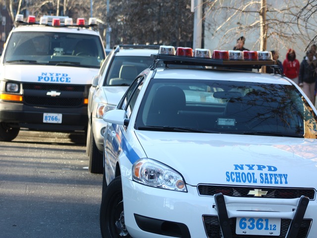 <p>A line of NYPD vehicles are parked outside the East 144th Street entrance of the South Bronx Preparatory school, where several laptops were discovered missing, on Jan. 7, 2013.</p>
