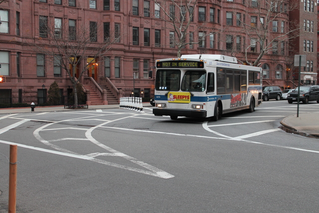 <p>A MTA bus turns at 120th Street and Mount Morris Park West. As an interim fix, the DOT has eliminated a turning lane at the intersection.</p>
